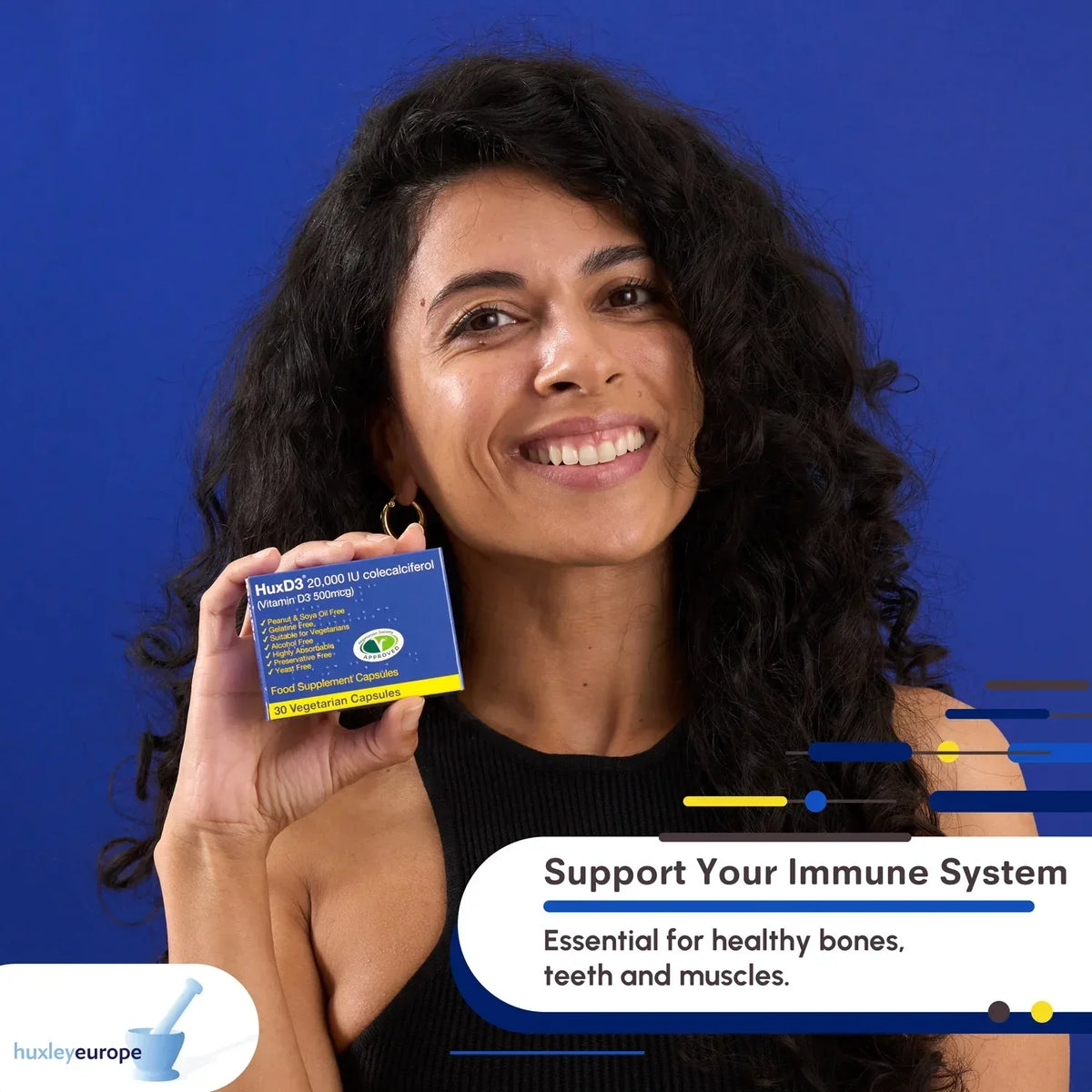 Smiling woman holding HuxD3 20,000 IU Vitamin D3 supplement capsules against a blue background.